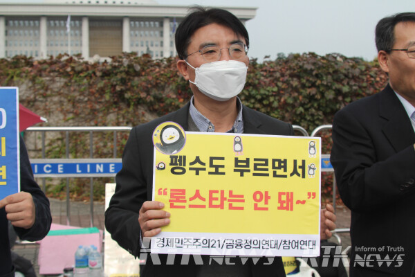 12일 오전 서울 영등포구 국회 앞에서 열린 '론스타 봐주기 국정감사 규탄 기자회견'에서 한 참가자가 피켓을 들고 있다. /남기두 기자
